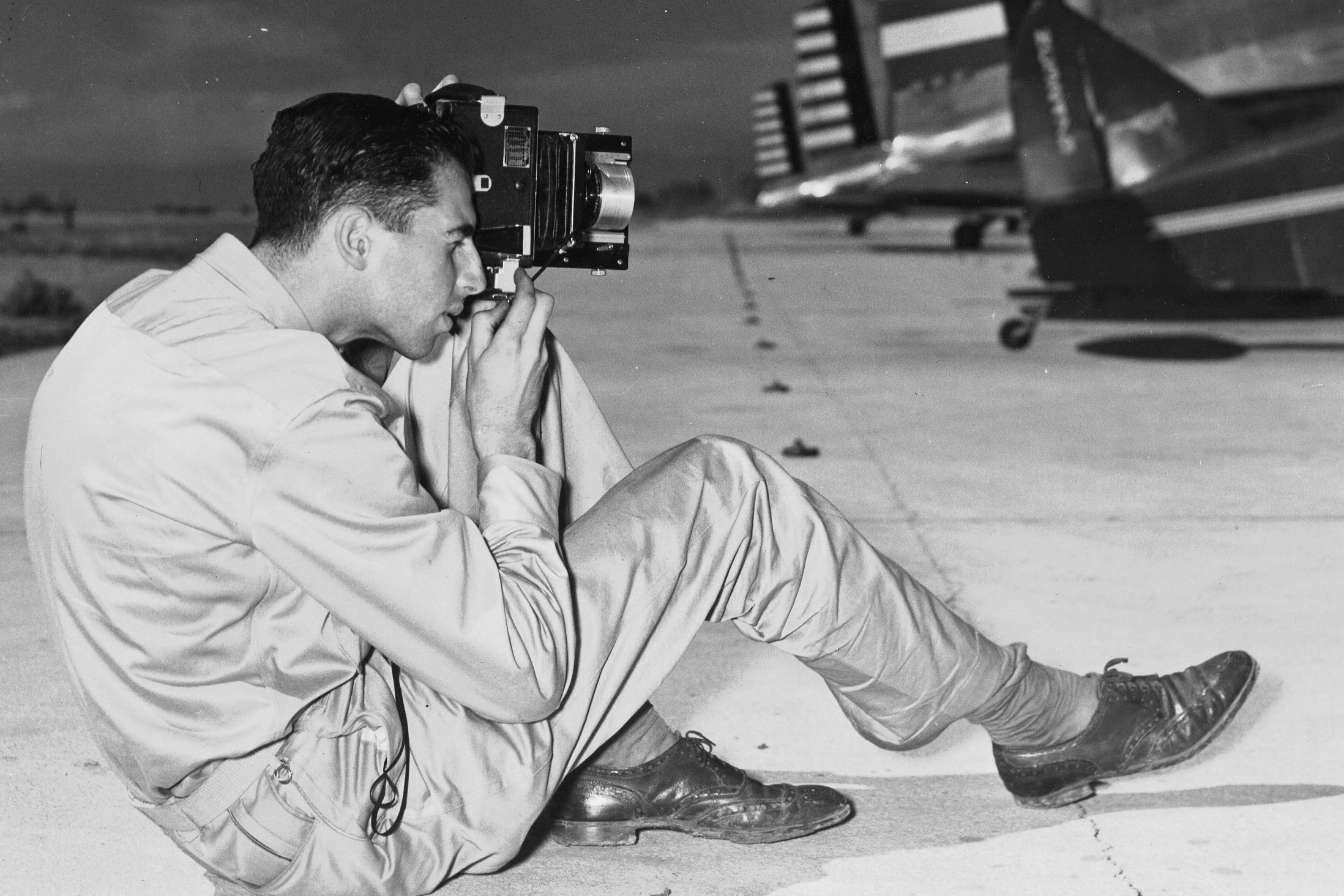 Historic photo of a photography trainee taking photos on a flight line